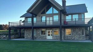 A large, modern house with a stone facade, multiple large windows, and a spacious balcony. - Ranch house in Arimo, Idaho with beautiful views, huge yard, and room to gather. (Arimo)