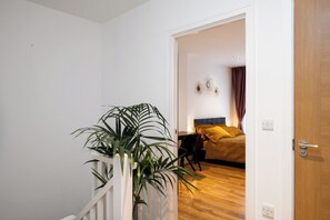 A room with a bed, a nightstand, and a potted plant. - 15 mins to Big Ben! Luxury large 2 Bed/3 Bath. FREE PARKING on request. (London)
