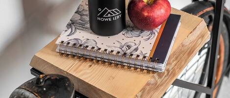 A bicycle with a wooden crate of apples, a black water bottle, and a notebook on the seat.