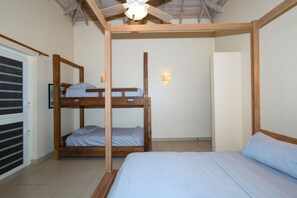 A room with a bunk bed, a single bed, a ceiling fan, and a wall-mounted light. - Turtle Cove House - Boutique 8-Bedroom Retreat with Ocean View (St. Johns)