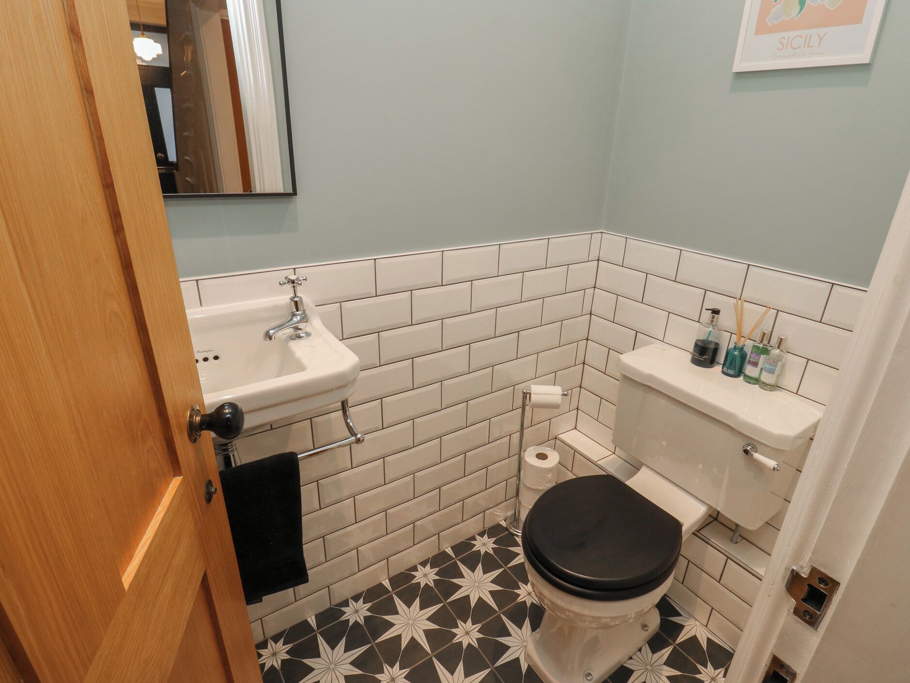 Ein Badezimmer mit Waschbecken, Toilette und gefliesten Wänden.