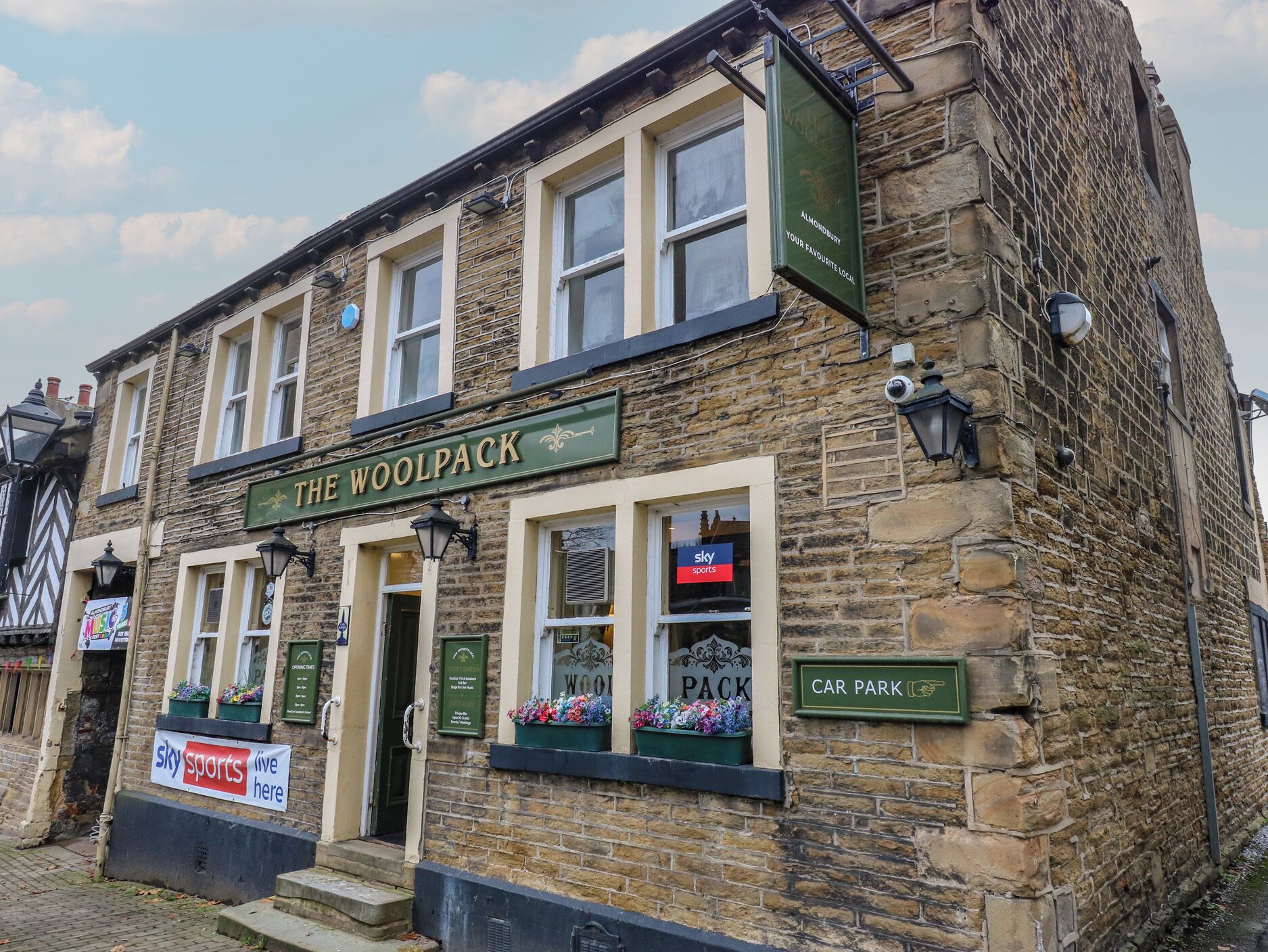 The Woolpack pub with a sign indicating a car park nearby.