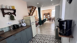 Una cocina con suelo estampado, una cafetera y un refrigerador.