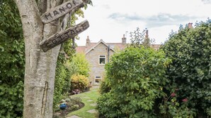 A stone house with a garden path leading to the entrance. - Manor Cottage (Scarborough)