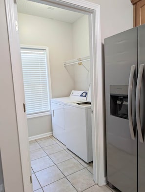 A laundry room with a washing machine, dryer, and refrigerator. - Alabama Daydreaming 3BD/2.5 bath *5 min to base*pool (Enterprise)