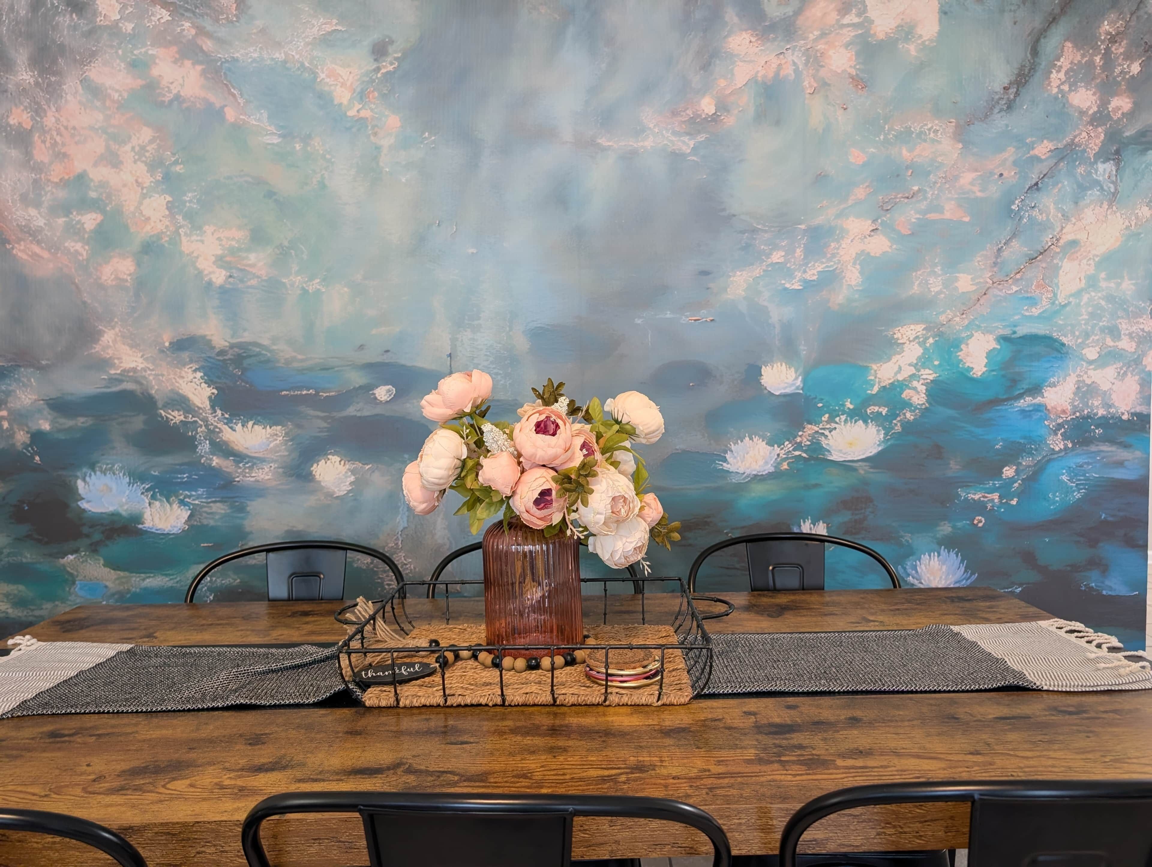A dining table with a vase of flowers, a placemat, and a placard with the word 'thankful.'