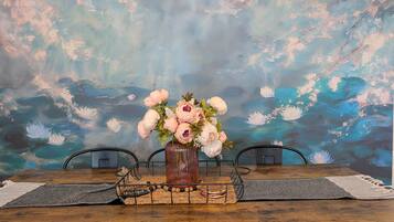 A dining table with a vase of flowers, a placemat, and a placard with the word 'thankful.'