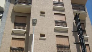 A hotel building with a sign reading "Hotel Isole" and a balcony with metal railings. - Hotel Doña Isabel (Elche)