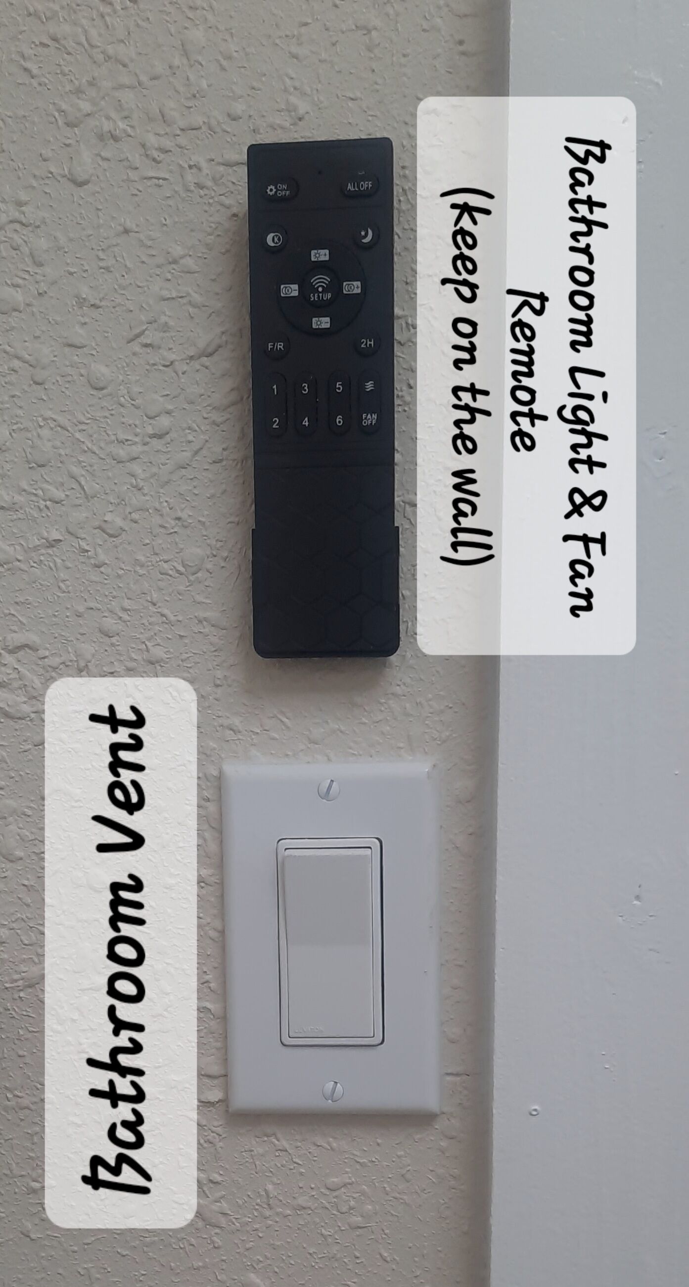 Een ventilatierooster en een afstandsbediening op een gestructureerde muur.