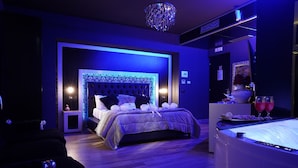 A modern bedroom with a tufted headboard, a bedside table with a lamp, and a nightstand. - HOTEL ANGIOINO & SPA (Naples)
