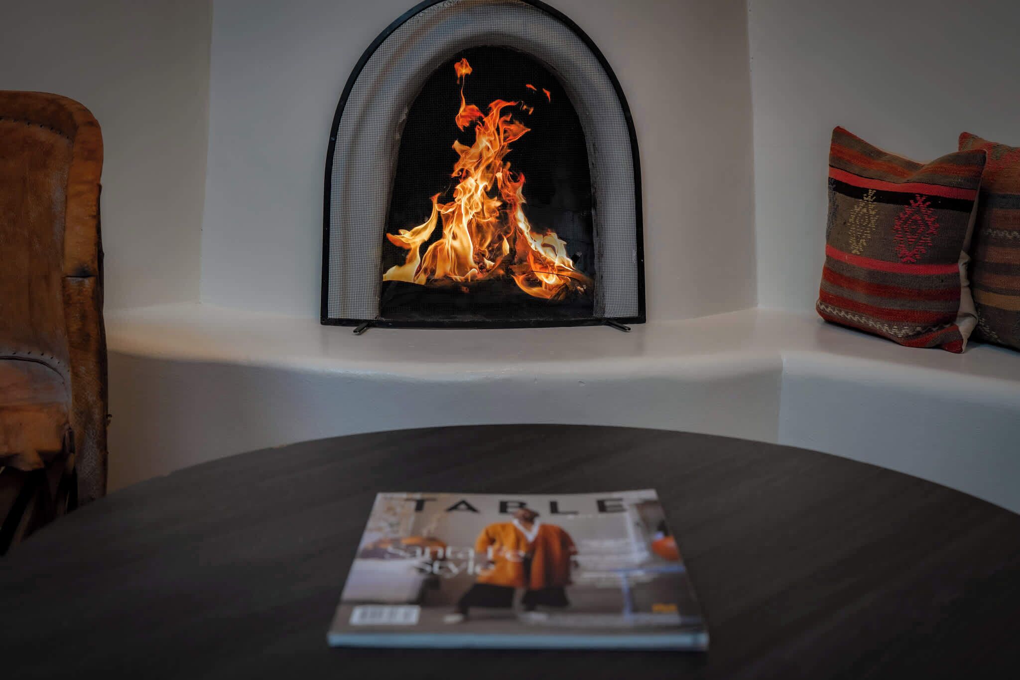 Una chimenea con una revista sobre una mesa.