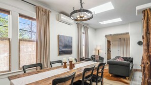 A dining area with a wooden table, chairs, and a chandelier. - Steps to the Plaza and Georgia O'Keeffe Museum (Santa Fe)