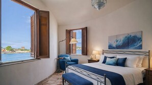 Une chambre à coucher avec un lit, un banc, une chaise, une lampe et un tableau.