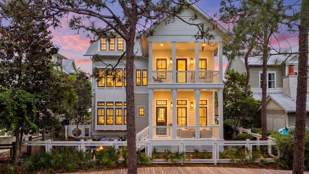 A two-story house with a balcony, surrounded by trees and a wooden deck. - Gulf Getaway with Private Pool and LSV (Santa Rosa Beach)