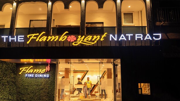 A restaurant named "The Flamboyant Natraj" with a neon sign and a glass facade. - The Flamboyant Natraj (Bharuch)