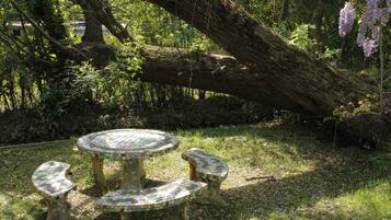 Uma mesa redonda com bancos de mosaicos num jardim.