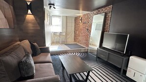 A modern living room with a sofa, a coffee table, a TV, and a fireplace. - Prospect Park Escape (Brooklyn)