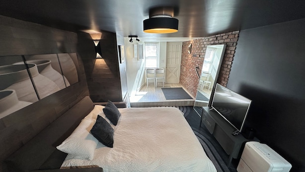 A modern bedroom with a bed, a desk, and a flat-screen TV. - Prospect Park Escape (Brooklyn)