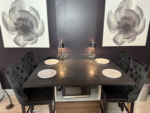 A dining table with four chairs, two lamps, and two plates. - Prospect Park Escape (Brooklyn)