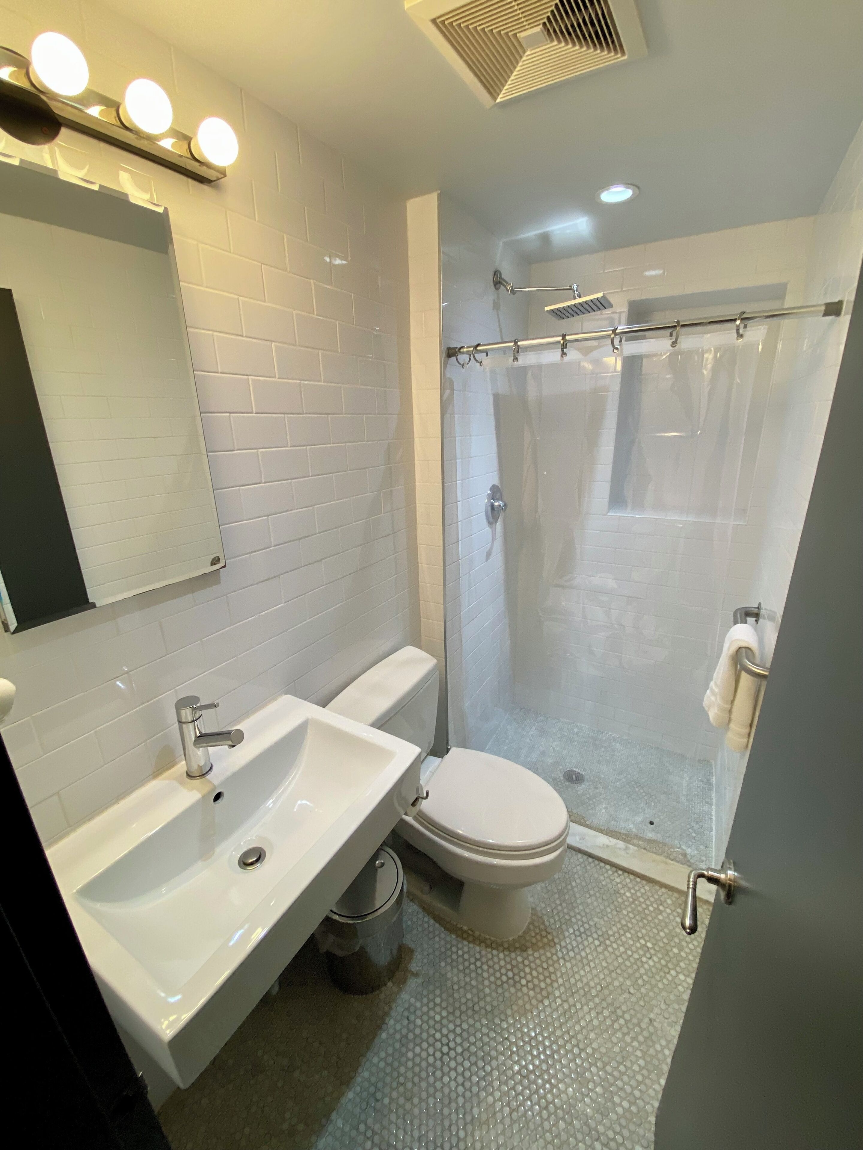 Une salle de bain moderne avec un lavabo blanc, des toilettes et une douche à parois de verre.