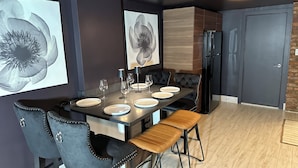 A modern dining area with a dark wood table, black upholstered chairs, and a wooden bench. - Prospect Park Escape (Brooklyn)