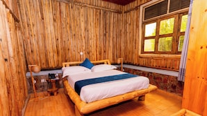 A wooden room with a bed, a window, and a bench.