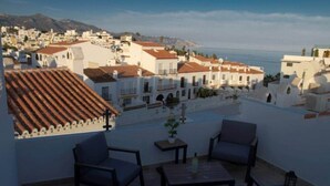 A rooftop terrace with white walls, red-tiled roofs, and a view of a coastal town. - Bajamar 13 Nerjarent nice sea and mountain view (Nerja)