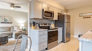 A compact kitchen with a microwave, oven, and refrigerator.