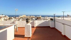 Eine Dachterrasse mit freiem Blick auf die Stadt und das Meer.
