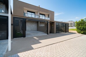 Ein modernes, zweistöckiges Haus mit Garage, Balkon und einer Fassade aus Naturstein.