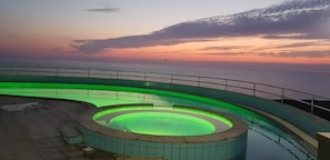 En säsongsöppen utomhuspool, parasoller och solstolar