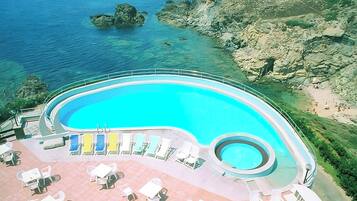 Una piscina al aire libre de temporada, sombrillas