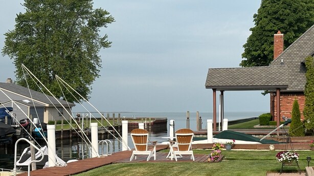 Une propriété située au bord de l’eau, dotée d’une terrasse couverte, d’un espace salon extérieur et offrant une vue sur l’eau.