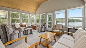 A spacious sunroom with large windows, a wooden ceiling, and a variety of seating options including sofas and chairs. - Richard's Island Pointe au Baril, in the sought after outer islands (Pointe au Baril)