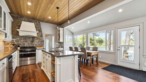 A spacious kitchen with a central island, built-in appliances, and large windows offering views of the outdoors. - Richard's Island Pointe au Baril, in the sought after outer islands (Pointe au Baril)