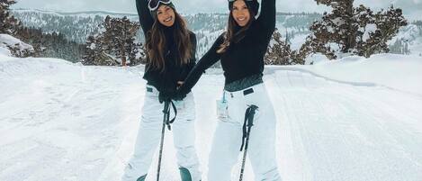 Zwei Personen auf Skiern vor einer verschneiten Berglandschaft.