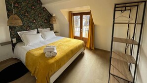 A bedroom with a bed, a hanging lamp, a window with curtains, and a metal shelf. - Les Fossiles - 4/6 people (Noyers-sur-Cher)