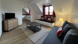 A modern loft apartment with a loft bed, a flat-screen TV, a sofa, and a dining area. - Les Fossiles - 4/6 people (Noyers-sur-Cher)