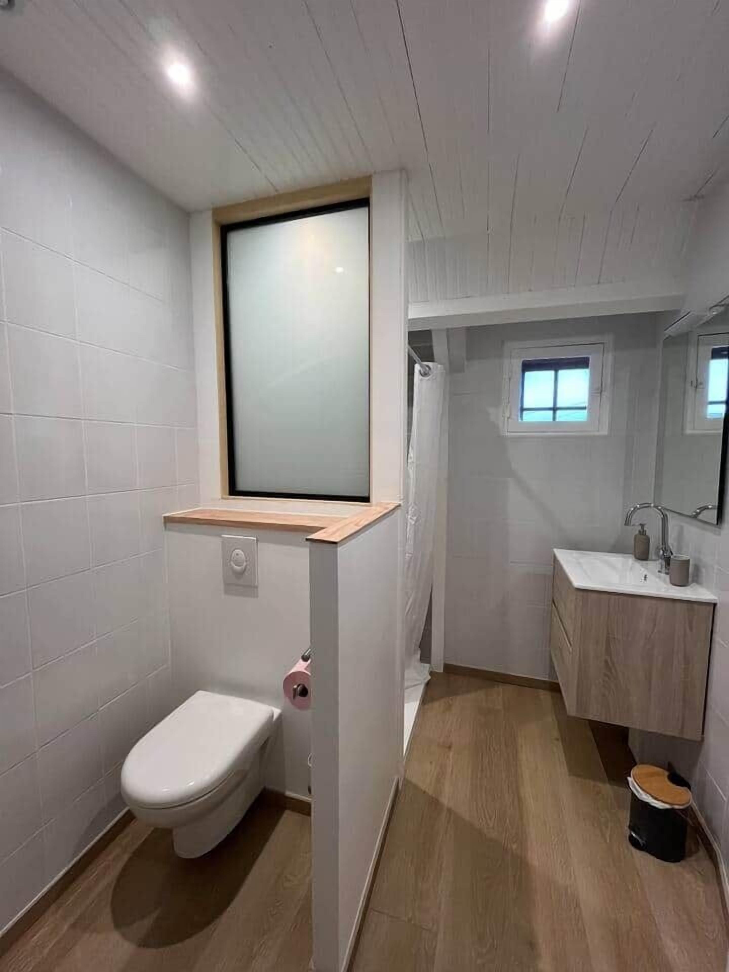 Un baño moderno con inodoro, lavabo y ducha.