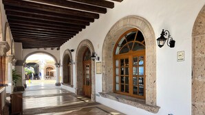 A corridor with arched doorways, a wooden door labeled "Lobby Lounge," and a tiled floor.