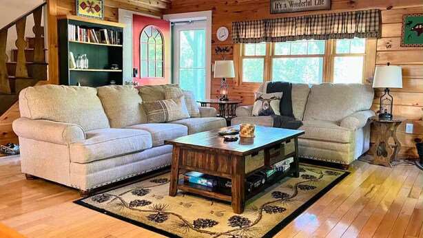 Ein gemütliches Wohnzimmer mit zwei Sofas, einem Couchtisch und einem Bücherregal.