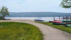 Ein Weg am Seeufer mit Bootsanleger und Picknicktisch.