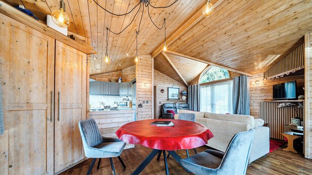 A cozy cabin interior with a wooden interior, a round table with chairs, a sofa, and a television. - Alpaca Farm, Views Sleeps 4, Parking, 1 Small dog (York)