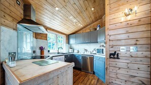 A kitchen with wooden walls, a central island, stainless steel appliances, and a window. - Alpaca Farm, Views Sleeps 4, Parking, 1 Small dog (York)