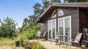 A wooden cabin with a deck, two chairs, and a table. - Alpaca Farm, Views Sleeps 4, Parking, 1 Small dog (York)