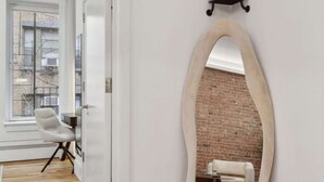 Ein modernes Interieur mit Holzboden, einer weißen Tür und einer Ziegelwand.