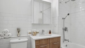 Een moderne badkamer met toilet, wastafel en bad.