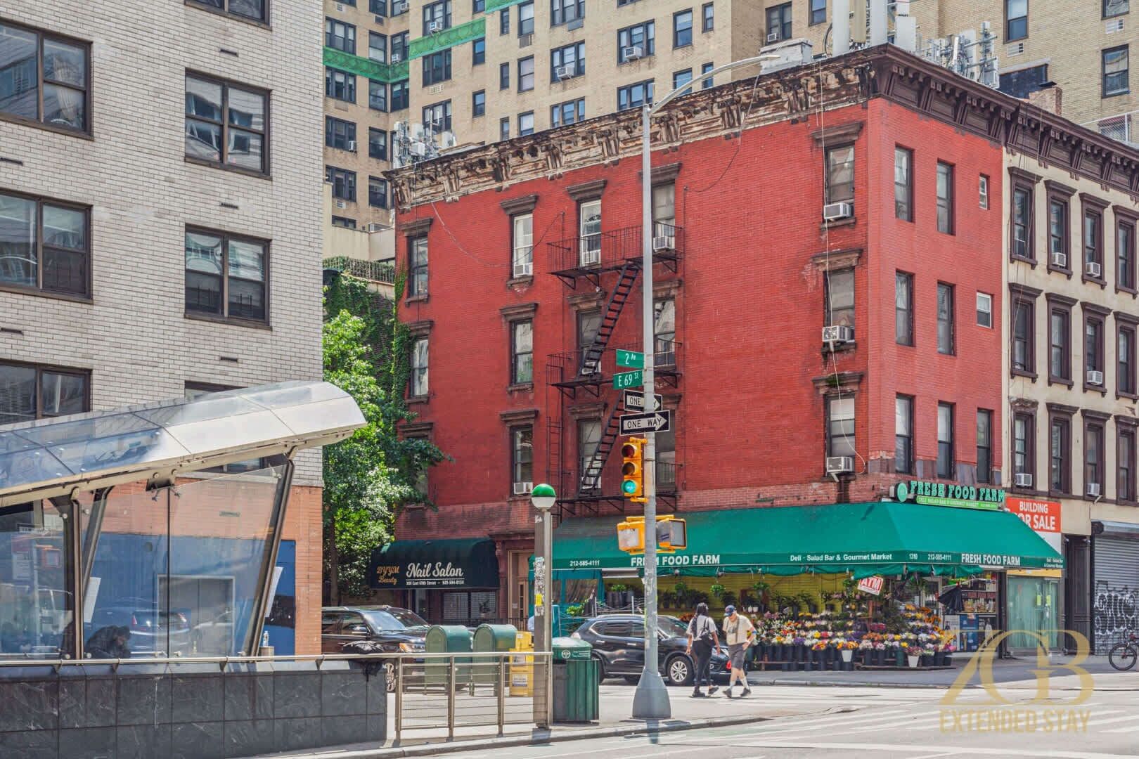 A street view with a red brick building, a green awning, and a visible storefront.