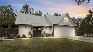 A two-story house with a front porch, a garage, and a driveway. - 5 Minutes from Lake / Cozy Mountain Home with a Heated Pool & Pool House! (Grant)
