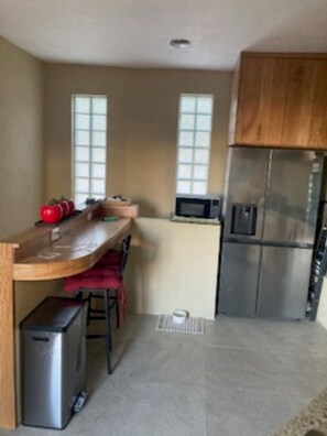 A kitchen with a wooden countertop, a stainless steel refrigerator, and a microwave. - Villa Upper Deck!  (Cabo San Lucas)